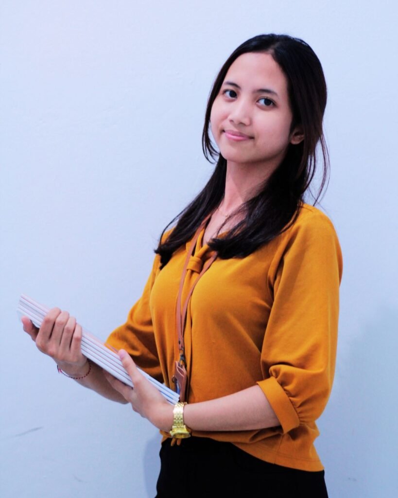 a woman holding a stack of papers